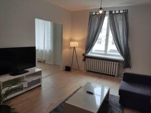 a living room with a couch and a tv and a table at Adorable Central Apartment Helsinki in Helsinki