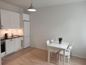a kitchen and dining room with a white table and chairs at Adorable Central Apartment Helsinki in Helsinki