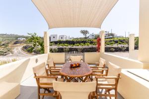 a table and chairs on the balcony of a house at Ampelos Executive Houses in Pyrgos +56 photos