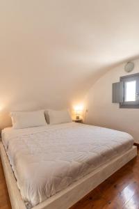 a large white bed in a room with a window at Ampelos Executive Houses in Pyrgos