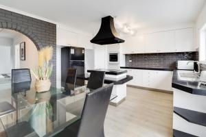 a kitchen with a glass table and black and white appliances at Highton Accommodation (Geelong) in Geelong