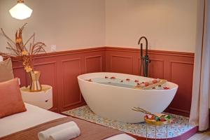 een badkamer met een groot bad in een kamer bij Miss Marguerite Suite in Parijs