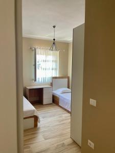 a small bedroom with two beds and a window at Twentysix Apartment in Shkodër