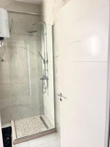 a shower with a glass door in a bathroom at Twentysix Apartment in Shkodër