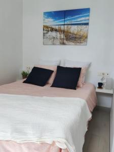 ein Schlafzimmer mit einem Bett mit einer rosa und weißen Decke in der Unterkunft Paradise room near the beach in Playa Honda