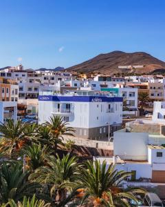 une ville avec des palmiers et des bâtiments blancs dans l'établissement ALTAVISTA APARTAHOTEL - Adults only, à Morro del Jable