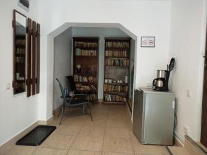 a hallway with a room with book shelves and a refrigerator at Casa Evanti in Sibiu