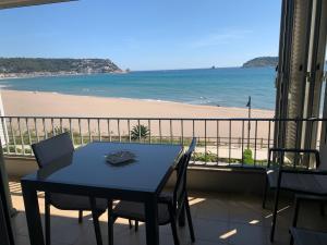 einen Tisch und Stühle auf einem Balkon mit Blick auf den Strand in der Unterkunft Voramar Viu Bé in L'Estartit