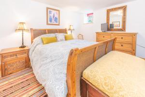 a bedroom with a bed and a dresser and a mirror at The Flat at number 11 in Newton Abbot