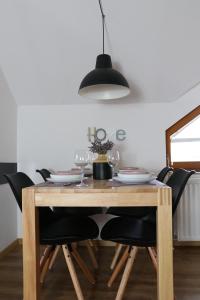 a dining room table with black chairs and a black lamp at Lusht'n apartma in Žirovnica +31 photos