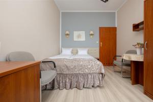 um quarto de hotel com uma cama e uma secretária em Willa Rawia em Rewal