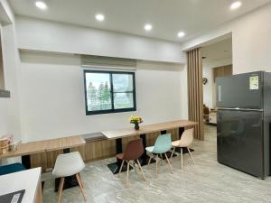 a kitchen with a table and chairs and a refrigerator at Travel Time Homestay in Huxi