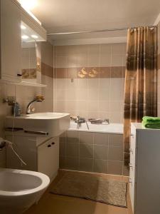 un bagno con lavandino, vasca e WC di Apartment in erster Seelinie in Morcote a Morcote