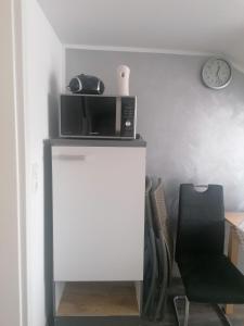 eine Mikrowelle auf einer Theke neben einem Stuhl in der Unterkunft Ferienwohnung Andreea in Saarlouis