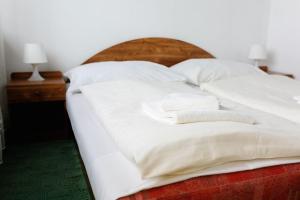 a bed with white sheets and two towels on it at Hotel Slovakia in Žilina