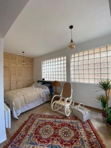 a bedroom with a bed and a chair and a rug at Lovely and peaceful vintage apartment near beach in Tivat