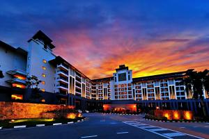 a building with a sunset in the background at Amazing Resort Suite at Pulai Springs Resort in Johor Bahru