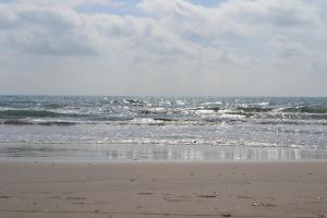 a person standing on a beach near the ocean at AGH Canet in Canet de Berenguer