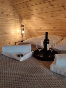 a room with two beds with wine glasses and towels at Domki przy plaży in Ryn