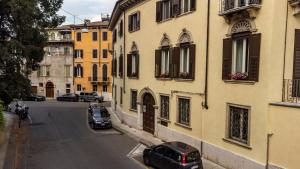 una calle con coches estacionados en el lateral de un edificio en Butterfly Boutique Rooms, en Verona