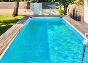 una piscina de agua azul en un patio en Superbe Villa 11 places à 400 m de la plage, en Andernos-les-Bains