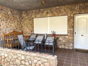 a room with a table and chairs in a stone wall at La casita de Riópar in Riópar