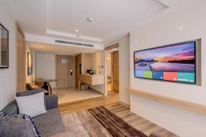 a living room with a large flat screen tv on a wall at Courtyard by Marriott North Pattaya in North Pattaya +61 photos