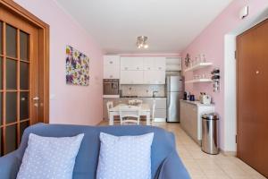 uma sala de estar com um sofá azul e uma cozinha em Morena - YourPlace Abruzzo em Fossacesia