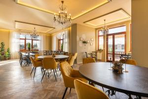 a dining room with tables and chairs and windows at Hotel Plumlov in Mostkovice