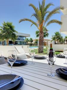 Antilia Terraces 3 Apartment -6309 في مار ذي كريستال: طاولة مع كؤوس النبيذ والنخيل