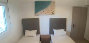 two beds sitting next to each other in a room at Maria Lemoni swimming pool apartment in Nea Skioni +30 photos