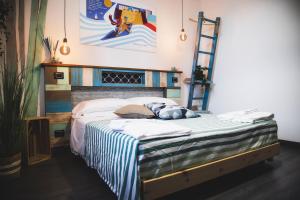 a bedroom with a bed with a striped blanket and a ladder at Homiday - Bel Salento Specchia in Specchia