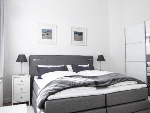 ein Schlafzimmer mit einem Bett, zwei Lampen und einem Spiegel in der Unterkunft Haus Westwind Hallwegh 04 in Norderney