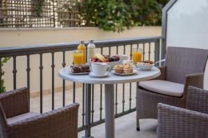 a table with food and drinks on a balcony at Casa De' Fiori Kefalonia in Skala Kefalonias