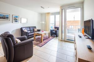 ein Wohnzimmer mit zwei Sofas und einem Fernseher in der Unterkunft Schippershuus 08 in Norderney