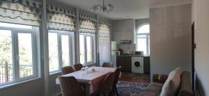 a dining room with a table and some windows at Brick House in Lahıc