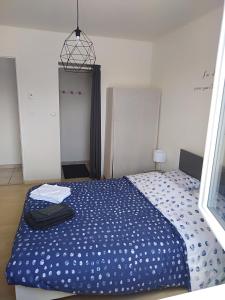 um quarto com uma cama com um edredão azul em Chambre agréable au calme em Saint-Hilaire-Petitville