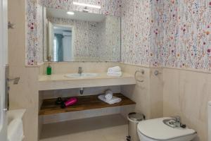 uma casa de banho com um lavatório, um espelho e um WC. em Mi Capricho Playa Marbella em Sitio de Calahonda