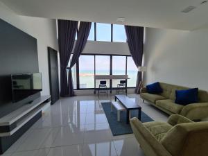 a living room with a couch and a tv and a table at Sunrise Gurney Premium Executive City/Seafront suite - Penang in George Town