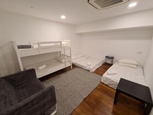 a white room with two beds and a chair at Sunrise Gurney Premium Executive City/Seafront suite - Penang in George Town