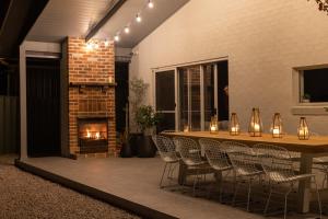 a patio with a table and chairs and a fireplace at Kuzman Estates in Mudgee