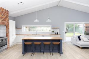 a kitchen with a large island with bar stools at Kuzman Estates in Mudgee +29 photos