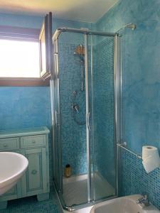 uma casa de banho azul com um chuveiro e um lavatório em PUNTA MOLARA em Monte Petrosu