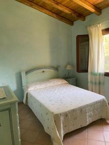 um quarto com uma cama num quarto com uma janela em PUNTA MOLARA em Monte Petrosu