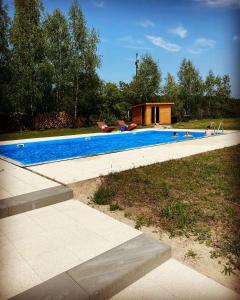 a swimming pool with a house in the background at Noce i Dnie in Postołowo