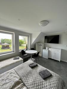 a bedroom with two beds and a table and a window at Apartamenty Ostoja in Łeba