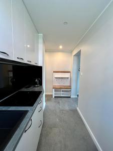 a kitchen with white cabinets and a sink at Apartamenty Ostoja in Łeba
