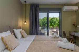 a bedroom with a large bed and a balcony at Casa De' Fiori Kefalonia in Skala Kefalonias