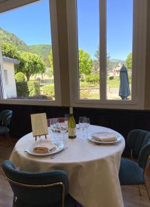 a table with a white table cloth and wine glasses at Hotel Beauséjour in Vic-sur-Cère