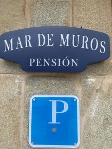 a sign for mar de murs permission on a stone wall at Mar De Muros in Muros